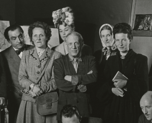 Jacques Lacan, Cécile Eluard, Pierre Reverdy, Louise Leiris, Zanie Campan Aubier, Pablo Picasso, Valentine Hugo, Simone de Beauvoir, Jean-Paul Sartre, Albert Camus, Jean Aubier, Michel Leiris et le chien Kazbek après la lecture du "Désir attrapé par la queue" chez les Leiris, dans l'atelier des Grands-Augustins, Paris, le 16 juin 1944